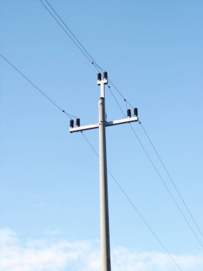 Mavi bulutlu gökyüzüne karşı elektrik direği.