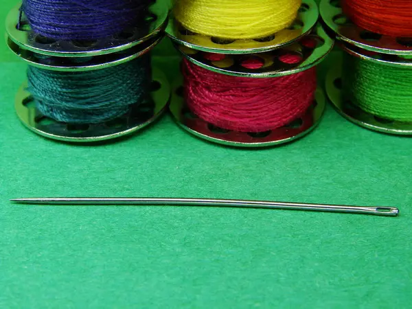 Renkli iplikler ve dikiş iğnesi