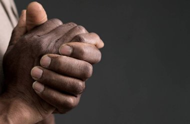 Tanrı 'ya gri siyah arkaplanda el ele dua ederken insanların resimlerini stokluyorlar.