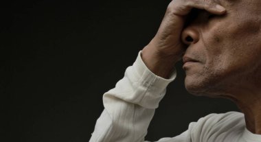 Siyah adam, insanların resimleriyle birlikte gri siyah arka planda Tanrı 'ya dua ediyor.