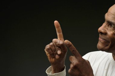 Adam koyu arkaplanlı parmağını gösterip insanların resimlerini basıyor.