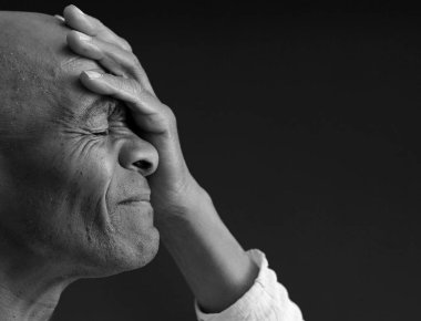 Siyah adam, gri siyah arka planda, insanların fotoğraflarıyla Tanrı 'ya dua ediyor.