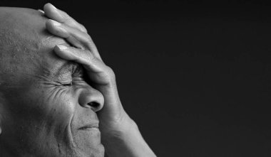 Siyah adam, gri siyah arka planda, insanların fotoğraflarıyla Tanrı 'ya dua ediyor.