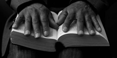 Adam Tanrı 'ya ellerinin birliğiyle dua ediyor Karayipli adam gri siyah arka planda dua ediyor insanların resimli çorap fotoğraflarıyla.