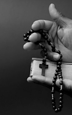 Adam Tanrı 'ya ellerinin birliğiyle dua ediyor Karayipli adam gri siyah arka planda dua ediyor insanların resimli çorap fotoğraflarıyla.