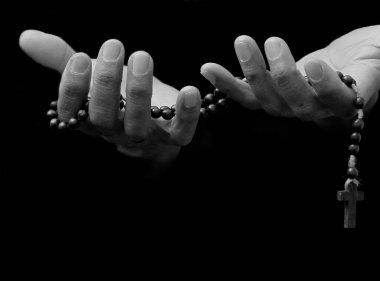 Adam Tanrı 'ya ellerinin birliğiyle dua ediyor Karayipli adam gri siyah arka planda dua ediyor insanların resimli çorap fotoğraflarıyla.