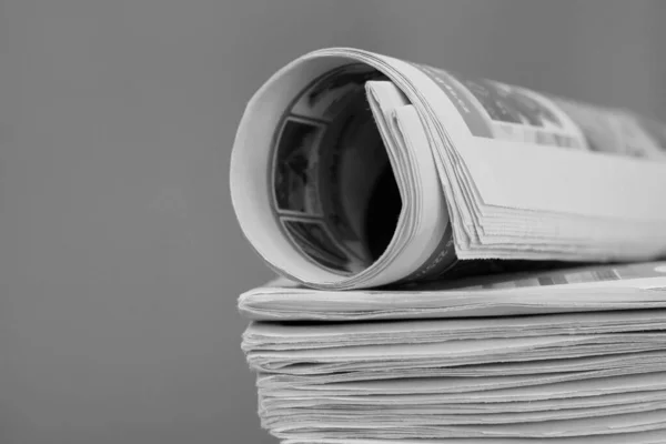 newspaper rolled up and sitting on a table no people stock image stock photo
