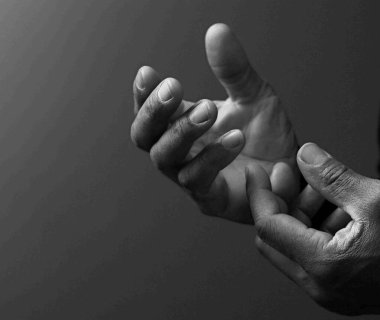 Adam Tanrı 'ya ellerinin birliğiyle dua ediyor Karayipli adam gri siyah arka planda dua ediyor insanların resimli çorap fotoğraflarıyla.