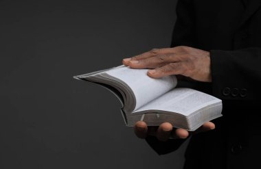 Adam Tanrı 'ya ellerinin birliğiyle dua ediyor Karayipli adam gri siyah arka planda dua ediyor insanların resimli çorap fotoğraflarıyla.