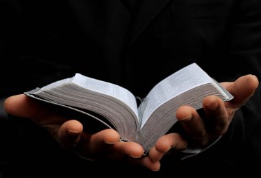 Adam Tanrı 'ya ellerinin birliğiyle dua ediyor Karayipli adam gri siyah arka planda dua ediyor insanların resimli çorap fotoğraflarıyla.