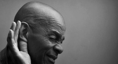 Sağır adam gri arka planda sağır ve işitme kaybı yaşıyor.