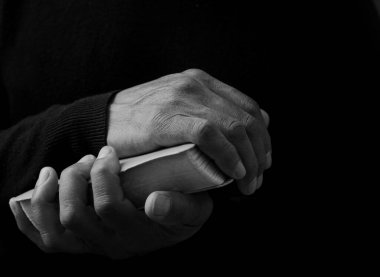 Adam Tanrı 'ya ellerinin birliğiyle dua ediyor Karayipli adam gri siyah arka planda dua ediyor insanların resimli çorap fotoğraflarıyla.