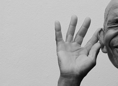 Sağır adam gri arka planda sağır ve işitme kaybı yaşıyor.