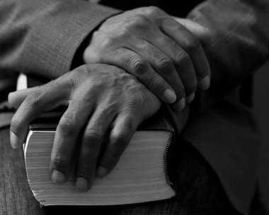 Tanrı 'ya gri siyah arkaplanda el ele dua ederken insanların resimlerini stokluyorlar.