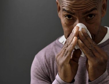 Grip kaptıktan sonra burun sümkürme ve grimsi siyah arkaplanlı soğuk algınlığı.