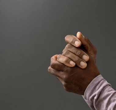 Adam Tanrı 'ya ellerinin birliğiyle dua ediyor Karayipli adam gri siyah arka planda dua ediyor insanların resimli çorap fotoğraflarıyla.