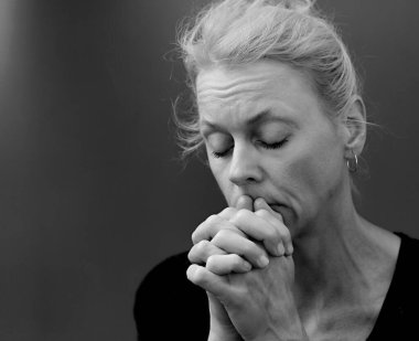 Tanrı 'ya dua eden bir kadın. Gri siyah arka planda birlikte dua eden bir kadın. İnsanların stoklarında resim fotoğrafı var.