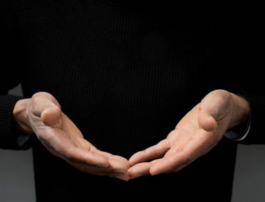 Adam Tanrı 'ya ellerinin birliğiyle dua ediyor Karayipli adam gri siyah arka planda dua ediyor insanların resimli çorap fotoğraflarıyla.