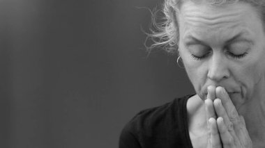 Tanrı 'ya dua eden bir kadın. Gri siyah arka planda birlikte dua eden bir kadın. İnsanların stoklarında resim fotoğrafı var.