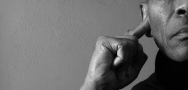 Sağır adam gri arka planda sağır ve işitme kaybı yaşıyor.