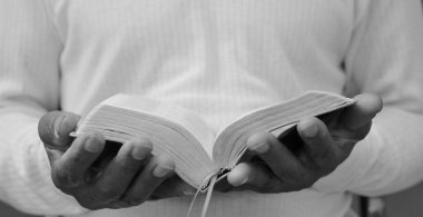 Adam Tanrı 'ya ellerinin birliğiyle dua ediyor Karayipli adam gri siyah arka planda dua ediyor insanların resimli çorap fotoğraflarıyla.