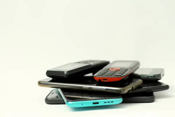 Telefones Celulares Velhos Empilhados Uma Mesa Com Fundo Branco Sem — Fotografia de Stock