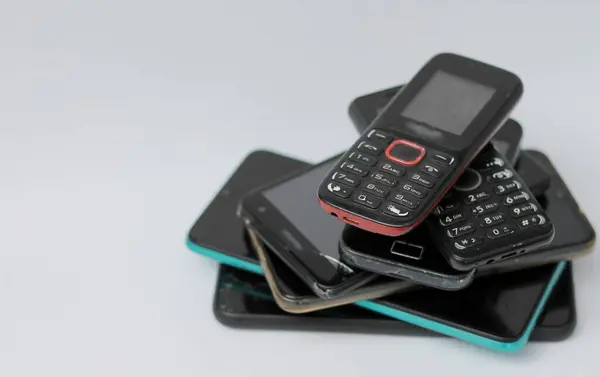 Vieux Téléphones Mobiles Empilés Sur Une Table Avec Fond Blanc — Photo