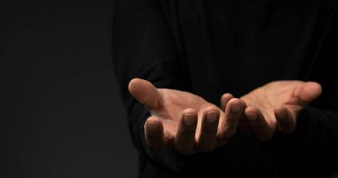 Tanrı 'ya gri siyah arkaplanda el ele dua ederken insanların resimlerini stokluyorlar.