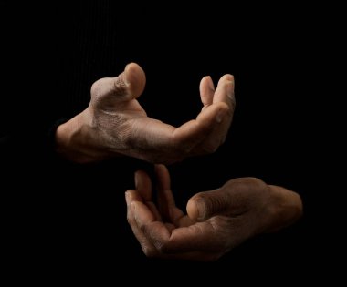 Siyahi adam Tanrı 'ya gri siyah arka planda el ele dua ederken insanların resimlerini stokluyor.