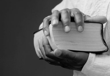 Tanrı 'ya gri siyah arkaplanda el ele dua ederken insanların resimlerini stokluyorlar.