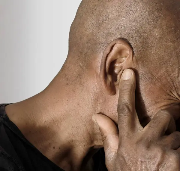 stock image deaf man suffering from deafness and hearing loss on grey black background with people stock image stock photo