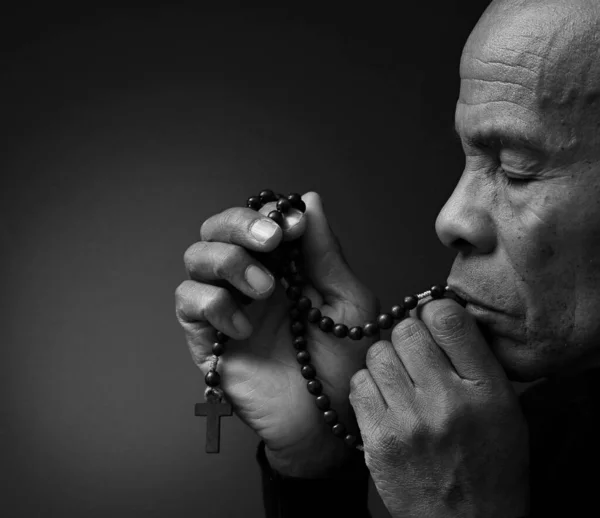 man praying to God on black grey background with people stock image stock photo