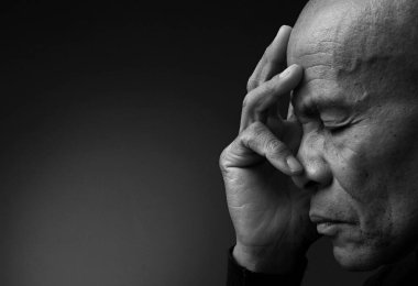 Adam siyah gri arkaplanda Tanrı 'ya dua ediyor ve insanların resimlerini stokluyor.