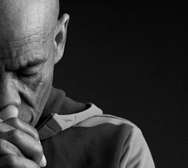Adam siyah gri arkaplanda Tanrı 'ya dua ediyor ve insanların resimlerini stokluyor.