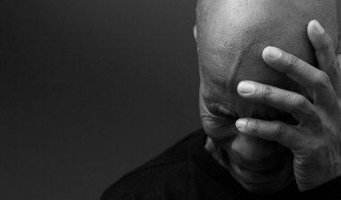 Adam siyah gri arkaplanda Tanrı 'ya dua ediyor ve insanların resimlerini stokluyor.