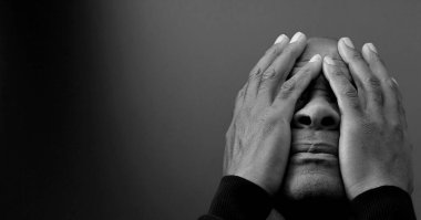 Adam siyah gri arkaplanda Tanrı 'ya dua ediyor ve insanların resimlerini stokluyor.