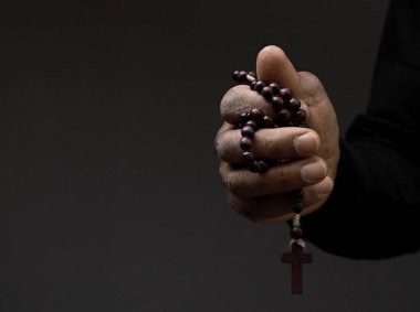 Tanrı 'ya gri siyah arkaplanda el ele dua ederken insanların resimlerini stokluyorlar.