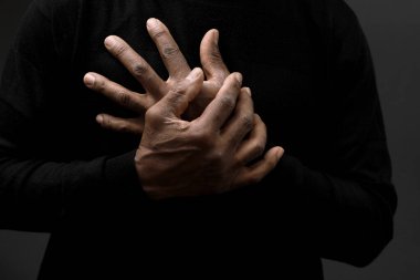 Tanrı 'ya gri siyah arkaplanda el ele dua ederken insanların resimlerini stokluyorlar.