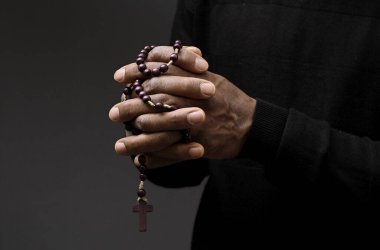 Tanrı 'ya gri siyah arkaplanda el ele dua ederken insanların resimlerini stokluyorlar.