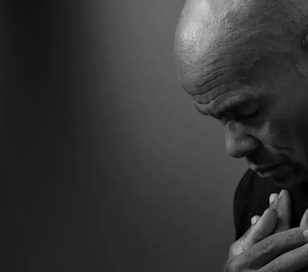 stock image man praying to God on black grey background with people stock image stock photo