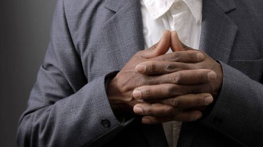 Adam Tanrı 'ya el ele dua ediyor. Karayipli adam, insanların fotoğraflarıyla siyah arka planda dua ediyor.