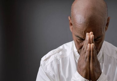 Siyah arka planda İncil 'le Tanrı' ya dua etmek ve insanların resimlerini stoklamak.