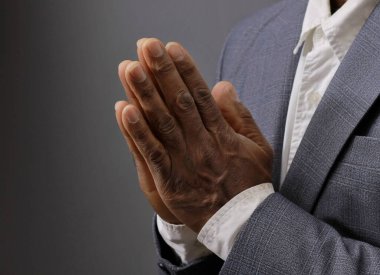 Tanrı 'ya dua ederken siyah gri arka planda el ele tutuşup insanların resimlerini stokluyorlar.