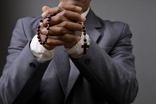 praying to God with hands together on black grey background with people stock image stock photo