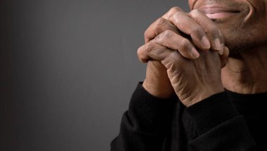 Siyah arka planda İncil 'le Tanrı' ya dua etmek ve insanların resimlerini stoklamak.