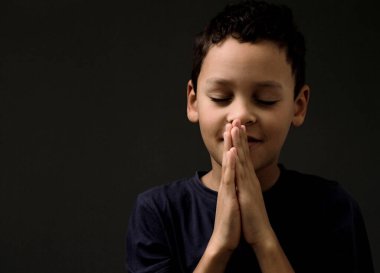 Küçük çocuk Tanrı 'ya el ele dua ediyor. 