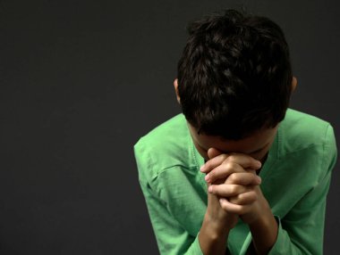 Küçük çocuk Tanrı 'ya el ele dua ediyor. 
