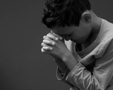Küçük çocuk Tanrı 'ya el ele dua ediyor. 