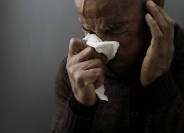 Grip ve nezle olduktan sonra burnu silmek. Gri siyah arka planda, insanların resimli fotoğrafları var.