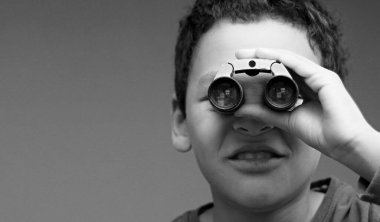Dürbünle bakan çocuk